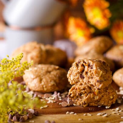 Several no bake breakfast cookies on a wood tray with flowers and coffee mugs in the background.