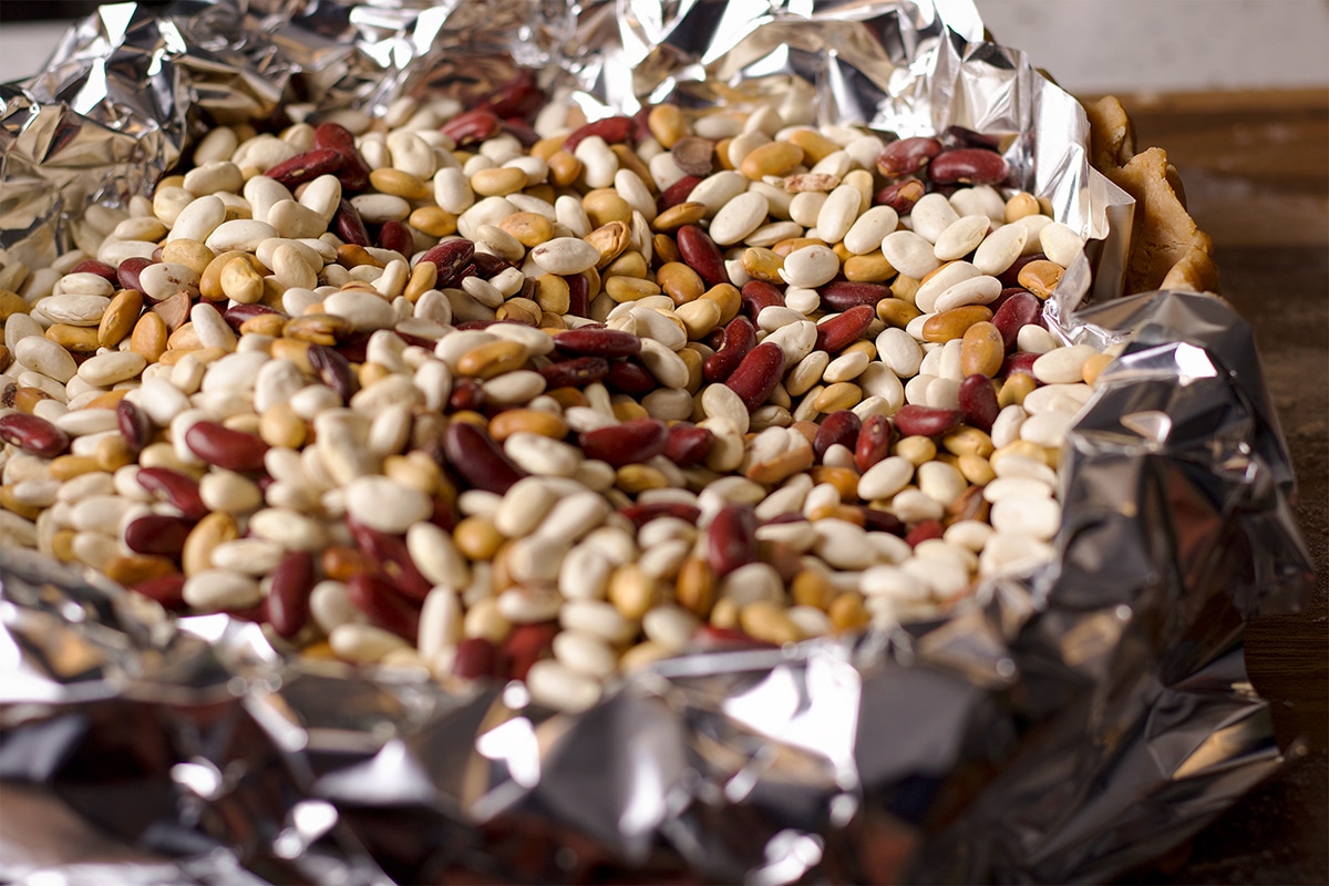 Dried beans fill a foil lined pie crust.