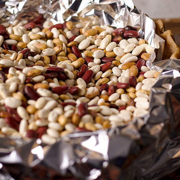 Using dried beans to weigh down toasted almond pie crust while it bakes.