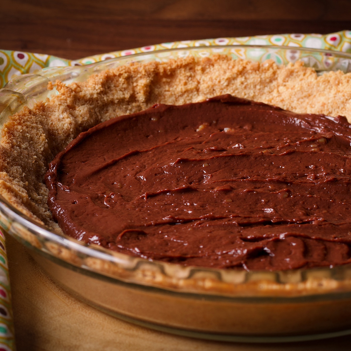 A pie plate containing a vanilla wafer crust and chocolate pastry cream.