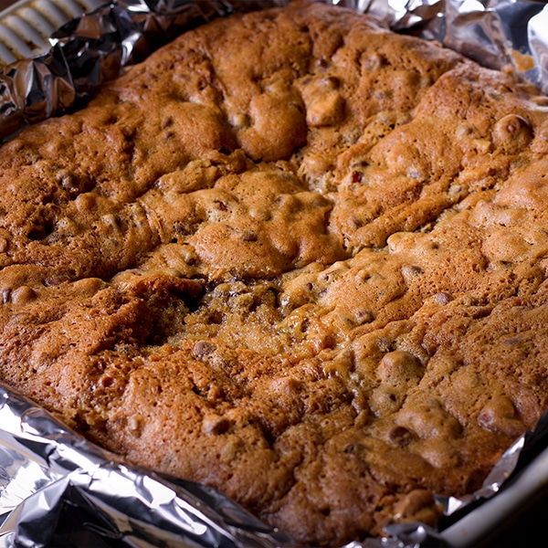 A pan of freshly baked chocolate chip cookie brownie bars.