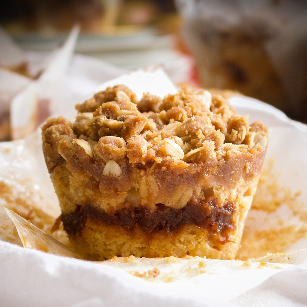 A freshly baked apple butter muffin on a white plate.