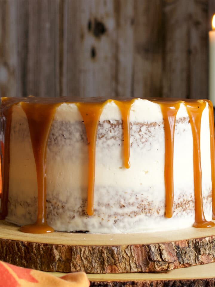 A two layer carrot cake covered in cream cheese buttercream and drizzled with caramel rum sauce.
