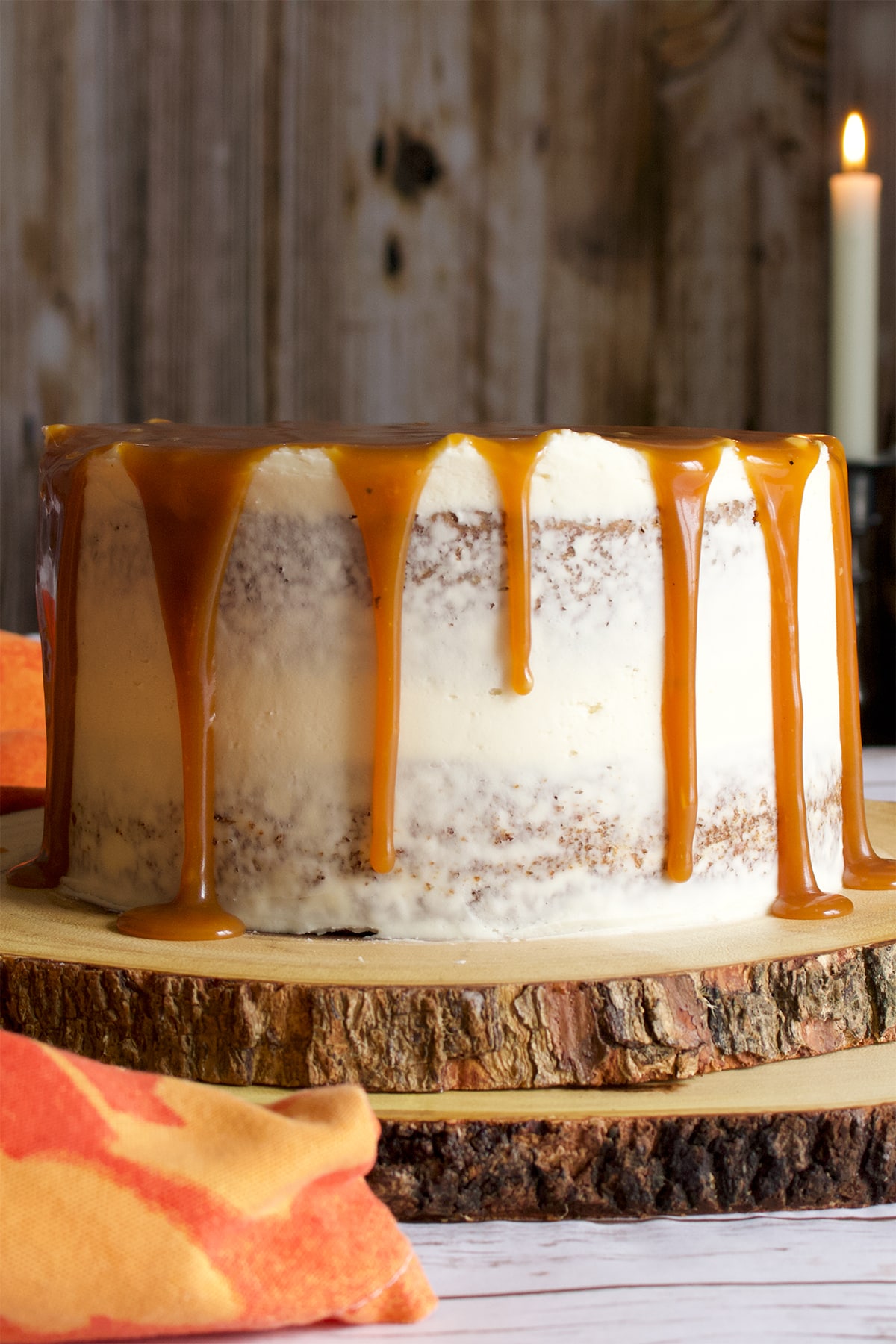 A two layer carrot cake covered in cream cheese buttercream and drizzled with caramel rum sauce.