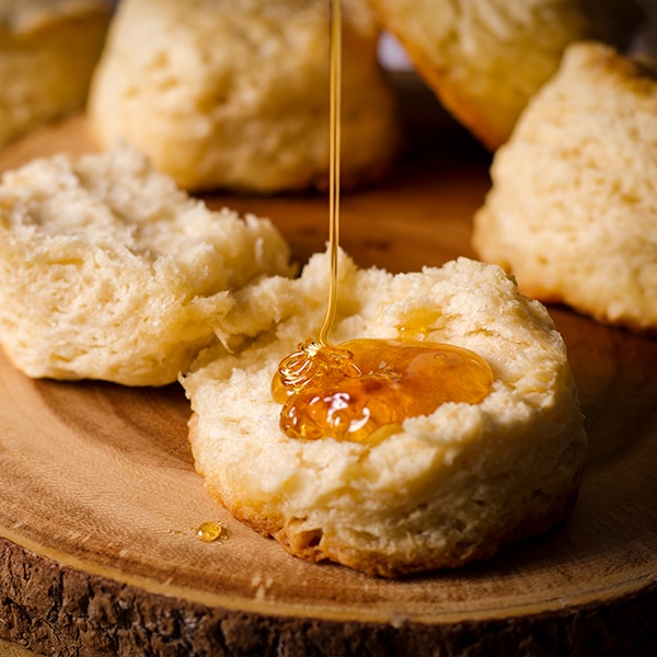 Drizzling a buttermilk biscuit with honey.