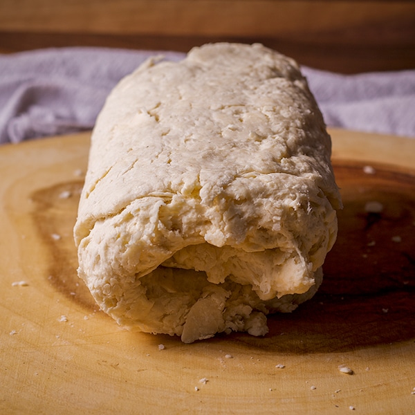 Folding over the dough of buttermilk biscuits to create layers.