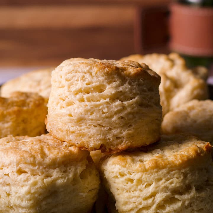 Several freshly baked buttermilk biscuits on a serving tray.