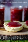 A biscuit cut in half and both sides slathered in a thick layer of homemade strawberry rhubarb jam.