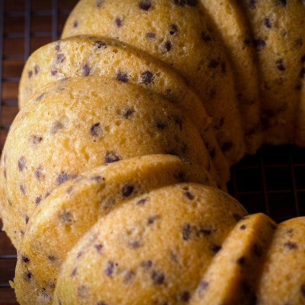 A freshly baked chocolate chip Bundt Cake cooling on a wire rack.