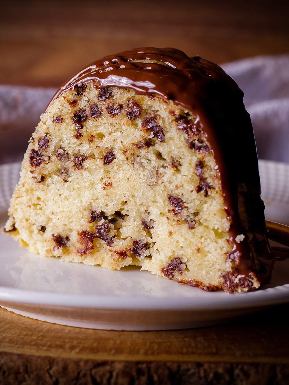 A slice of chocolate chip Bundt Cake on a plate, ready to eat.