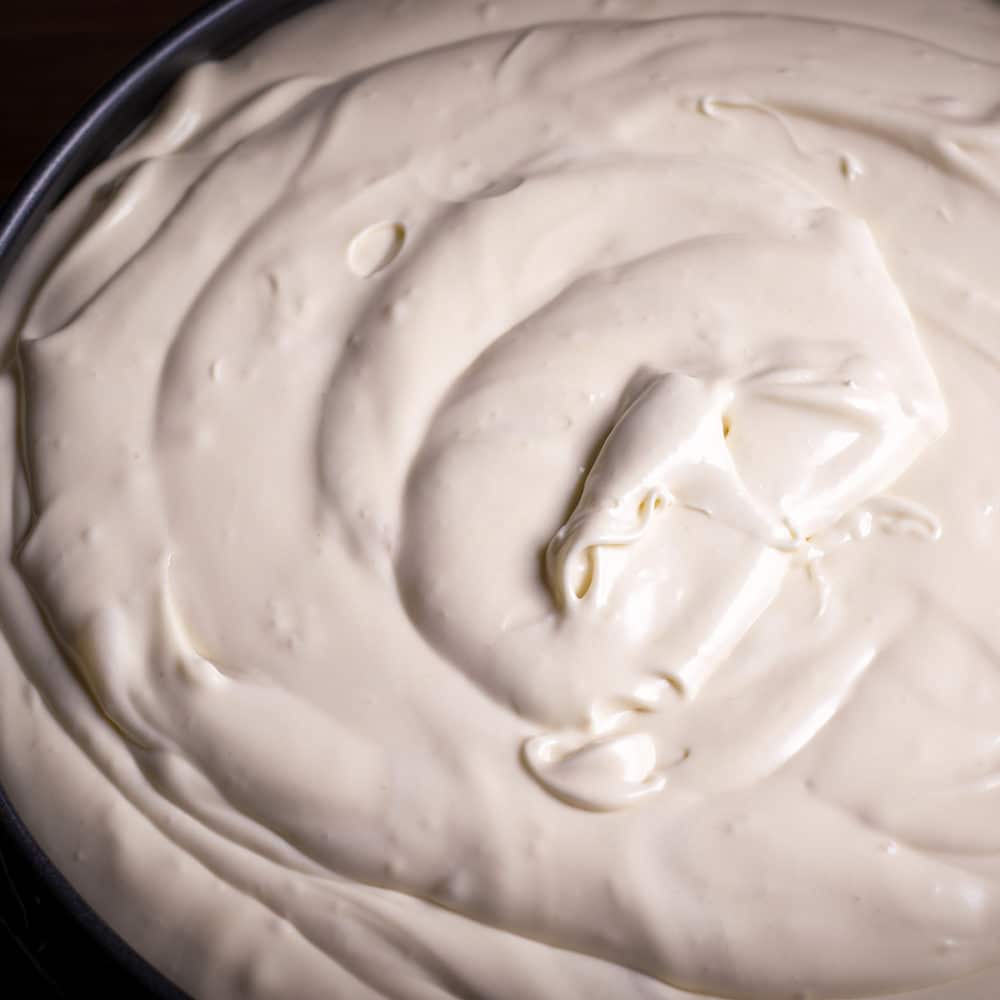A springform pan that's been filled to the top with New York Style Cheesecake batter.