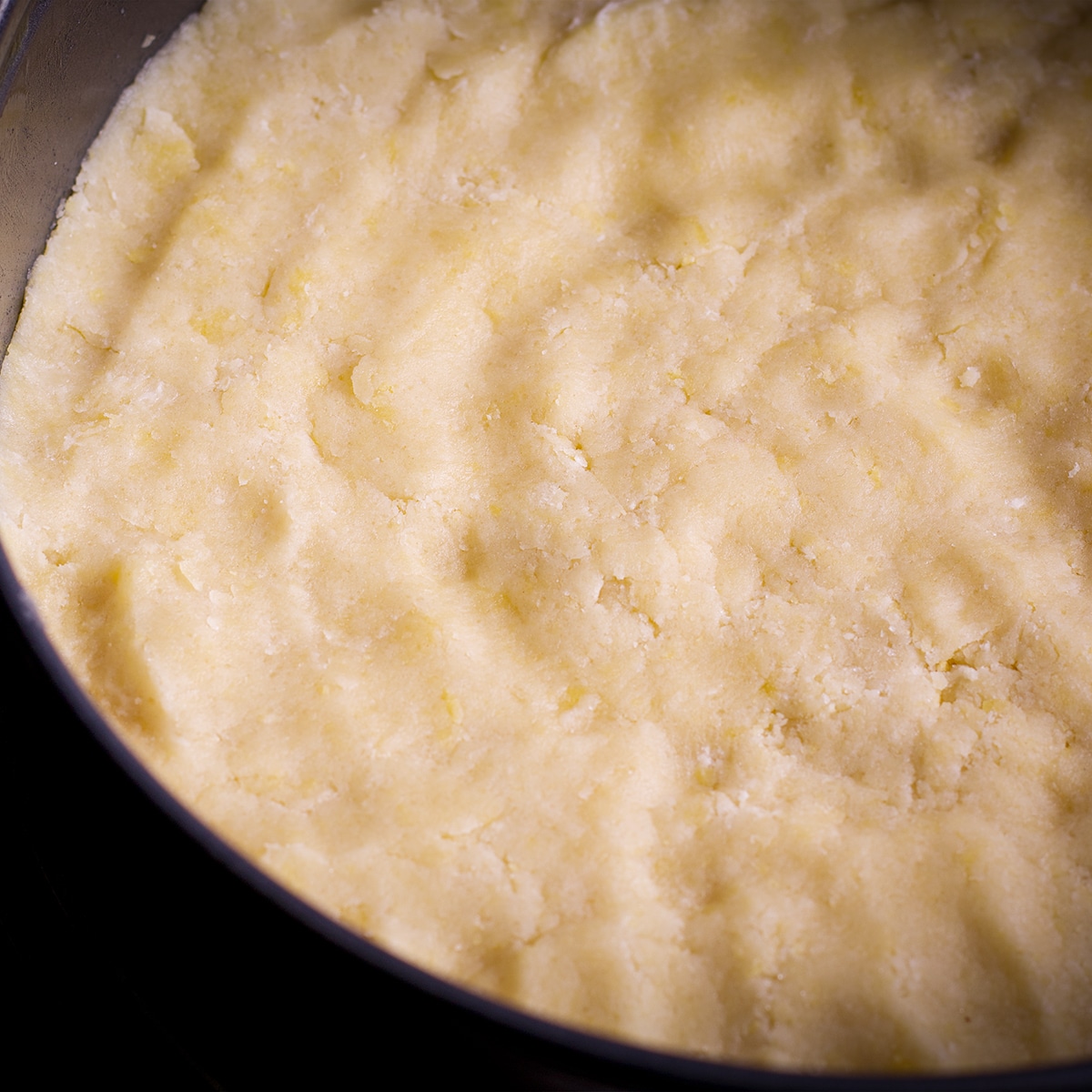 Pressing shortbread dough into a springform pan.