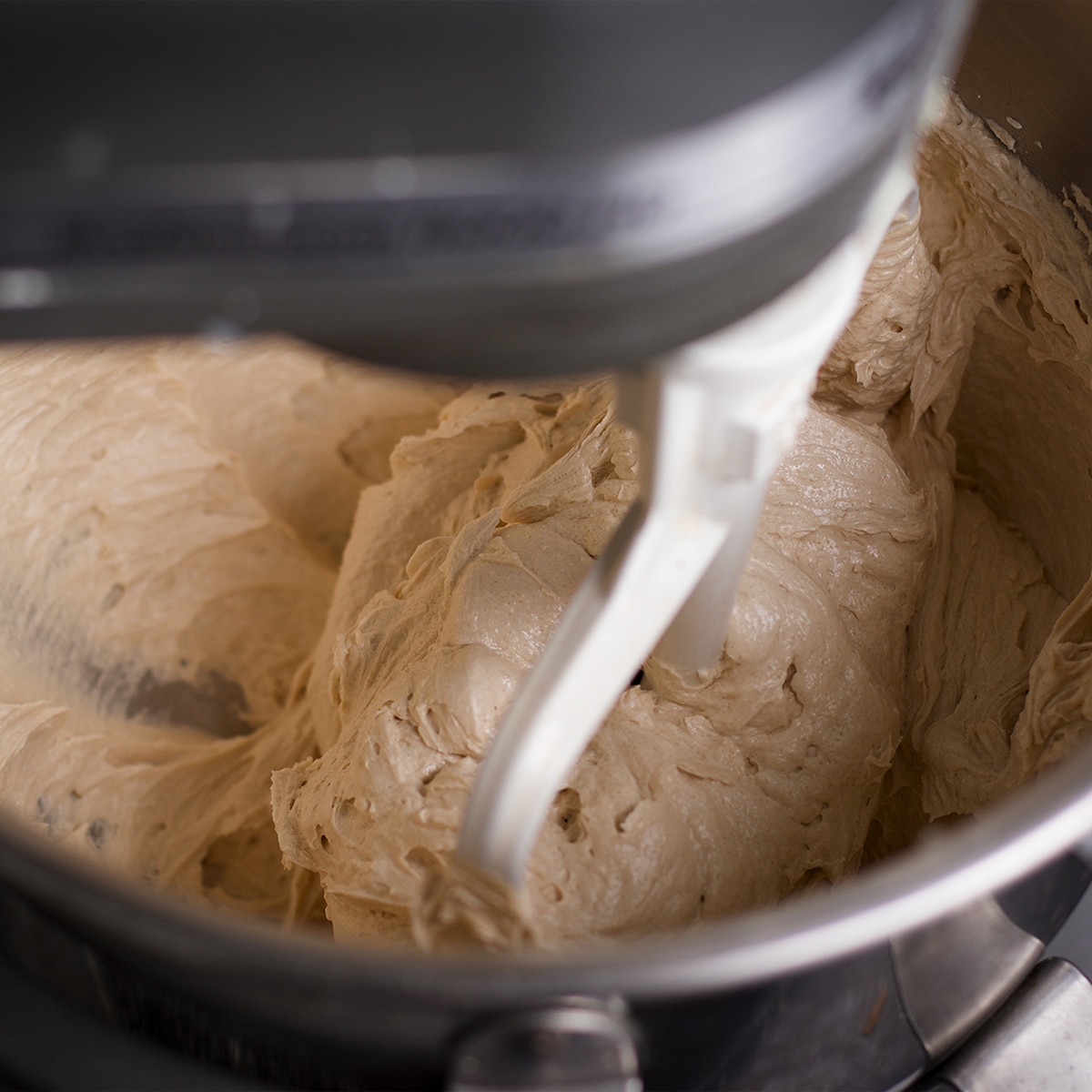 Using an electric mixer to beat butter with brown sugar and granulated sugar.