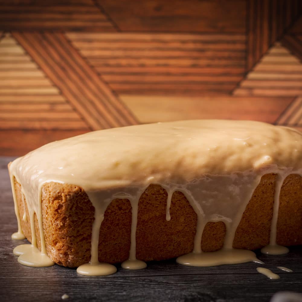 A vanilla loaf cake that's just been covered in vanilla glaze.