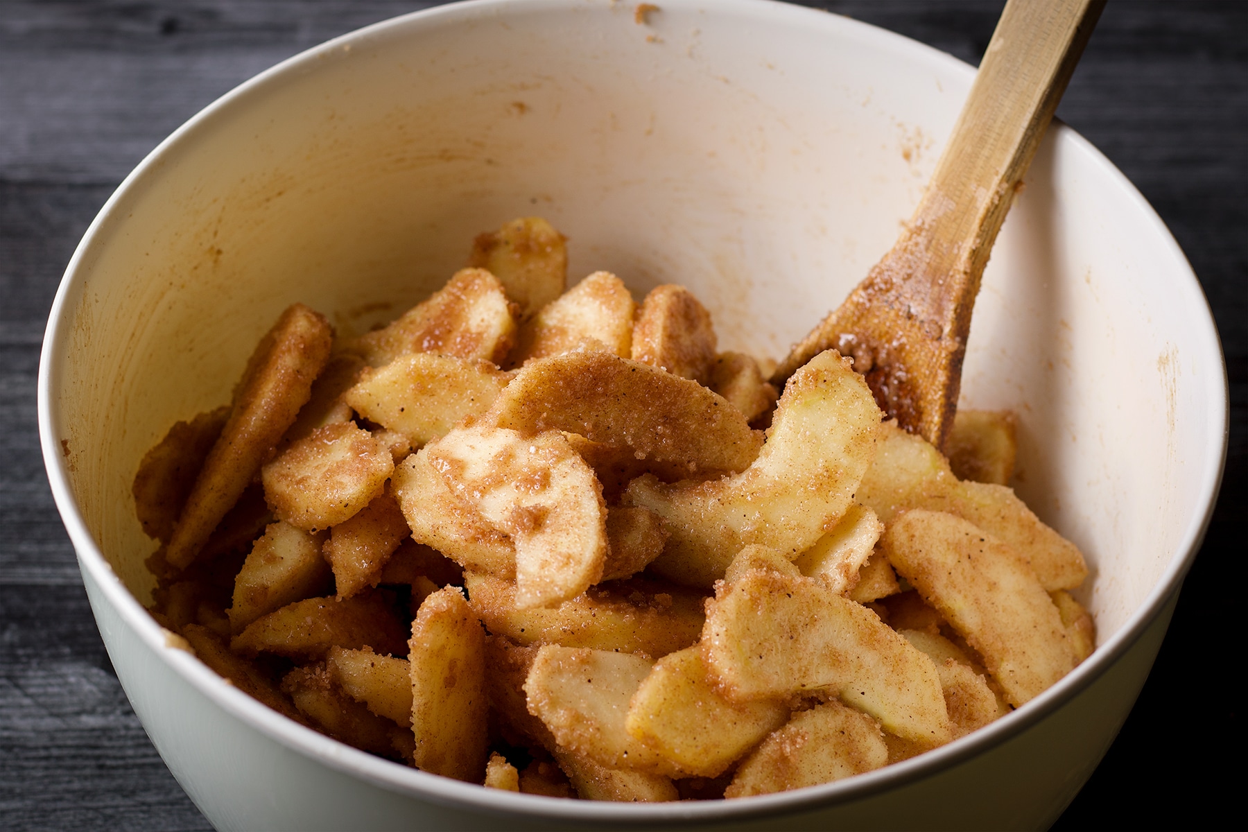 Stirring apples with cinnamon and sugar to make German Apple Pie
