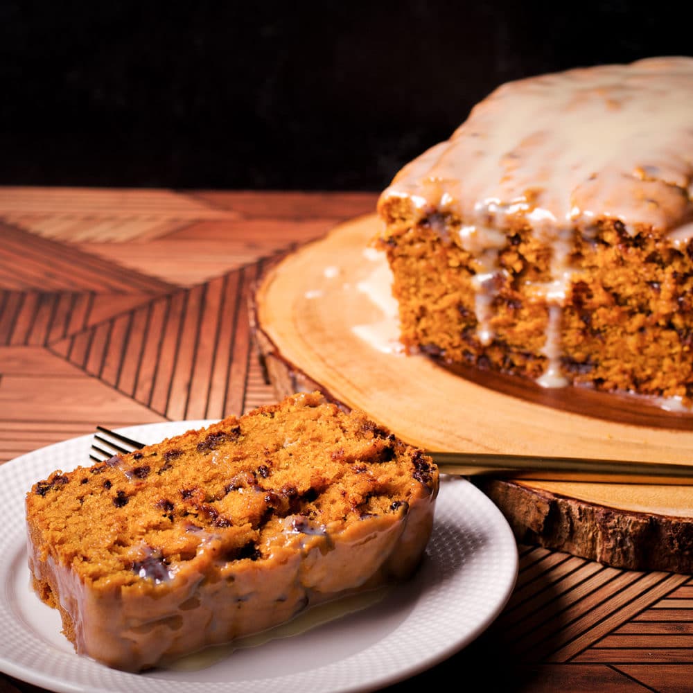 A slice of pumpkin chocolate chip bread on a white plate.
