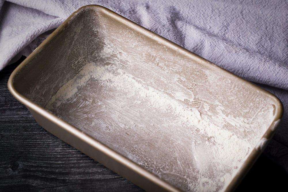 A loaf pan that's been greased and floured to prevent chocolate loaf cake from sticking.