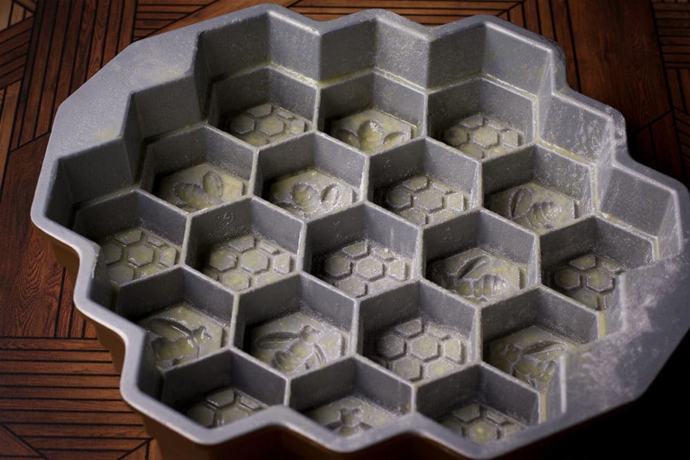 A honeycomb pan that has been sprayed with non-stick baking spray and dusted with flour.