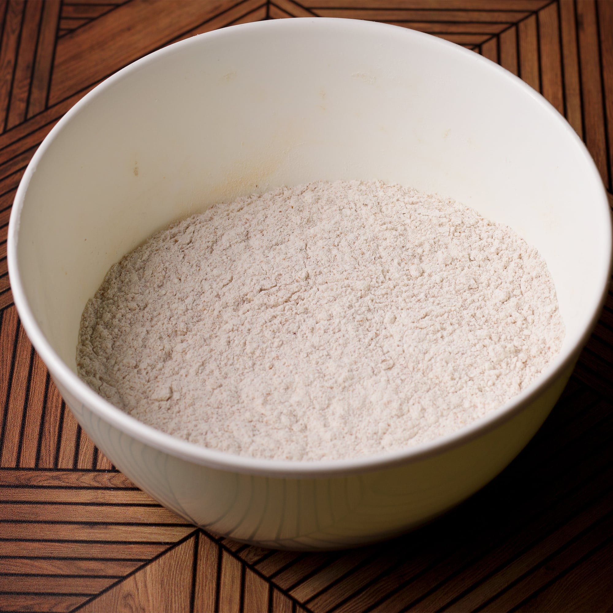 All the dry ingredients for honey cake blended together in a white bowl.