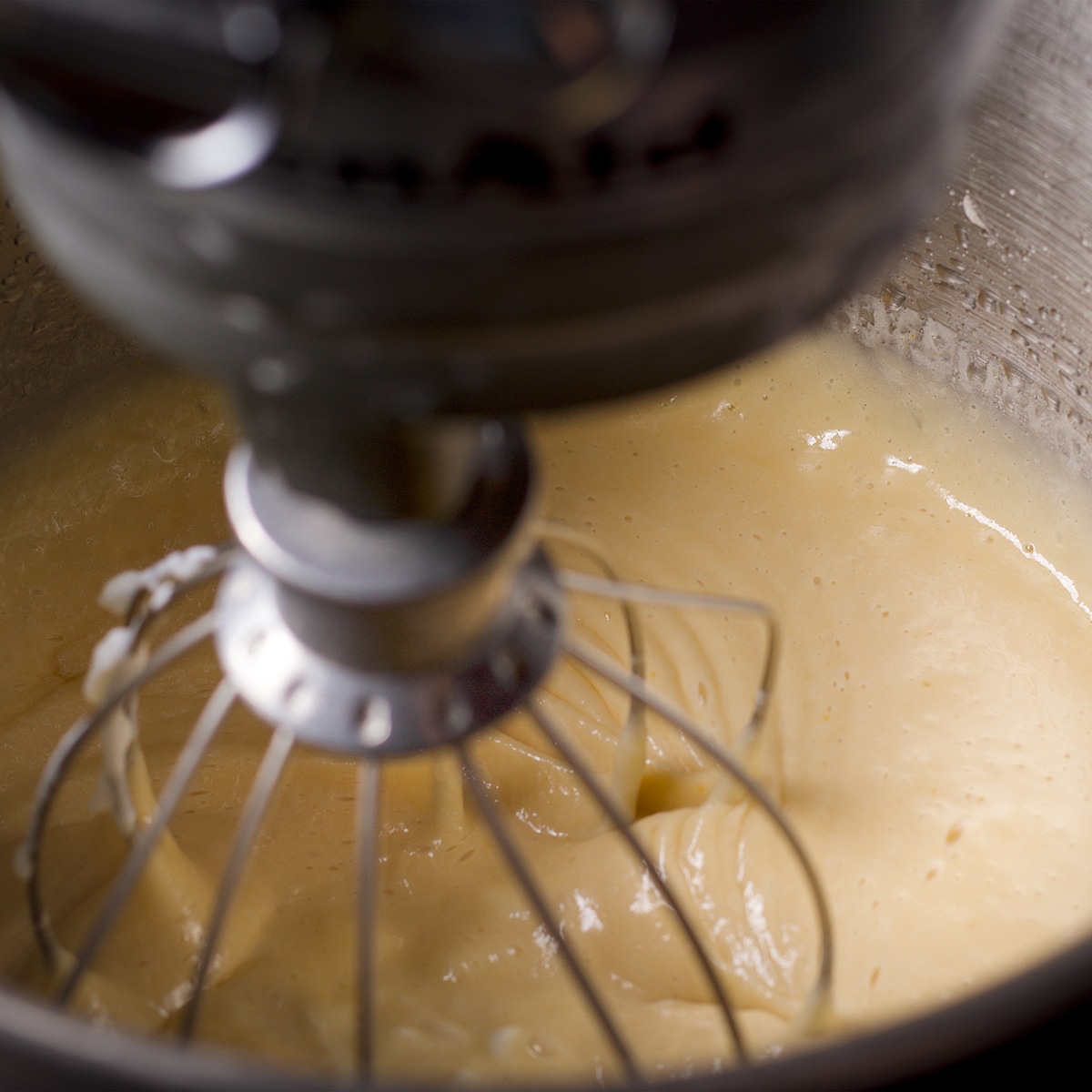 Mixing yogurt and vanilla into the loaf cake batter.