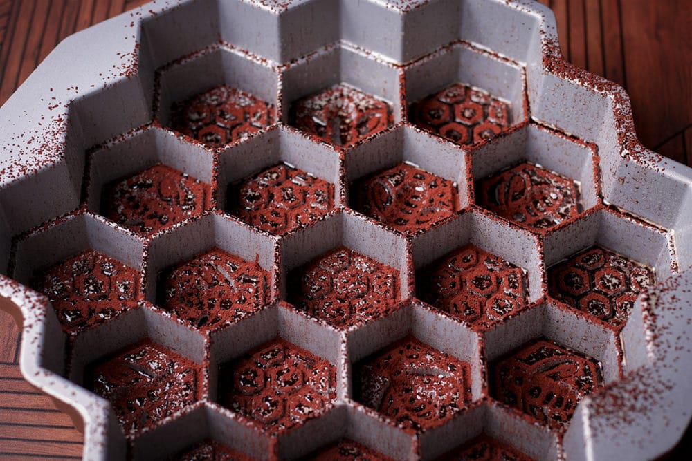A honeycomb pan that's been brushed with butter and coated with a thin layer of cocoa powder to prevent a cake from sticking to it while it bakes.