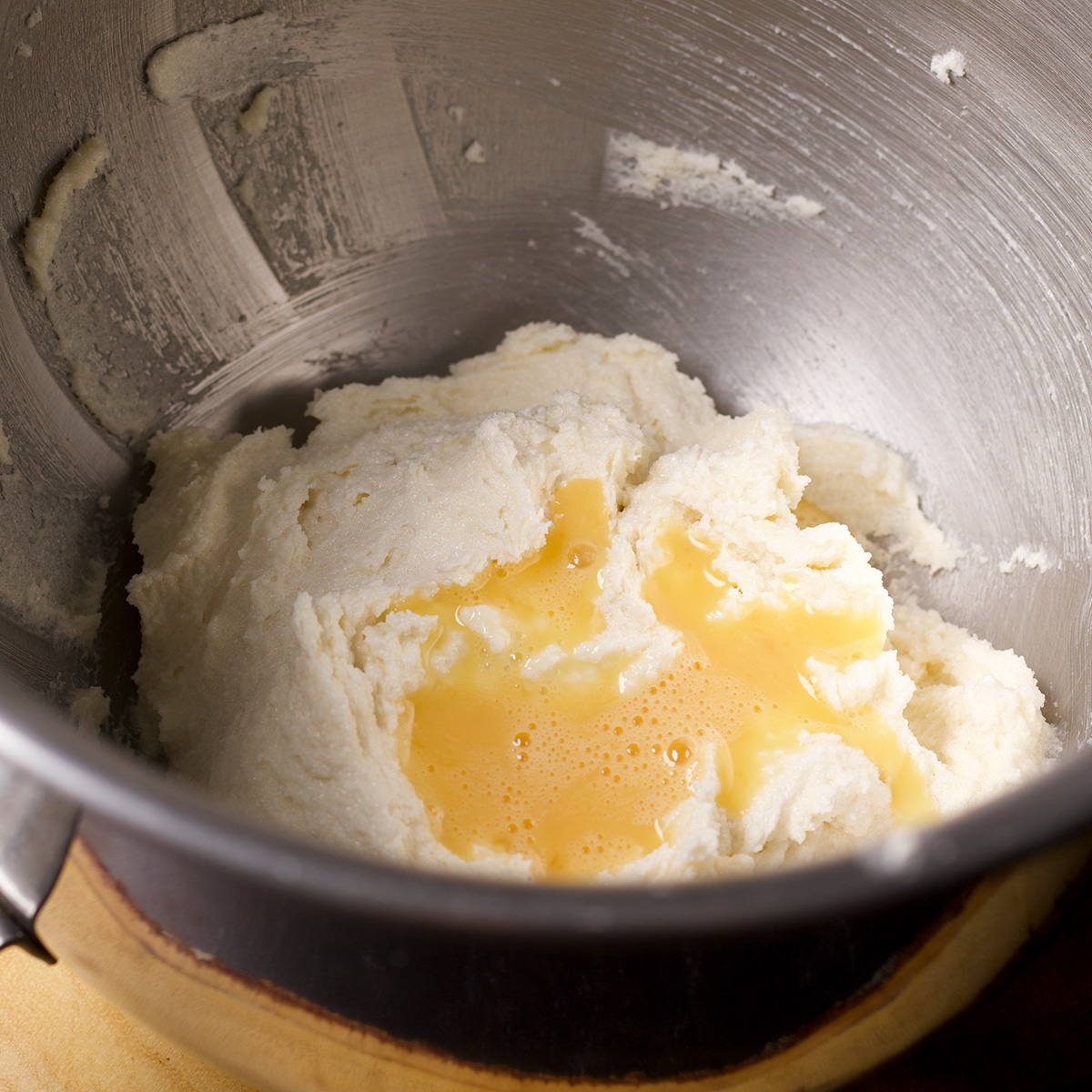 Beaten eggs that have been poured into a bowl containing butter and sugar.