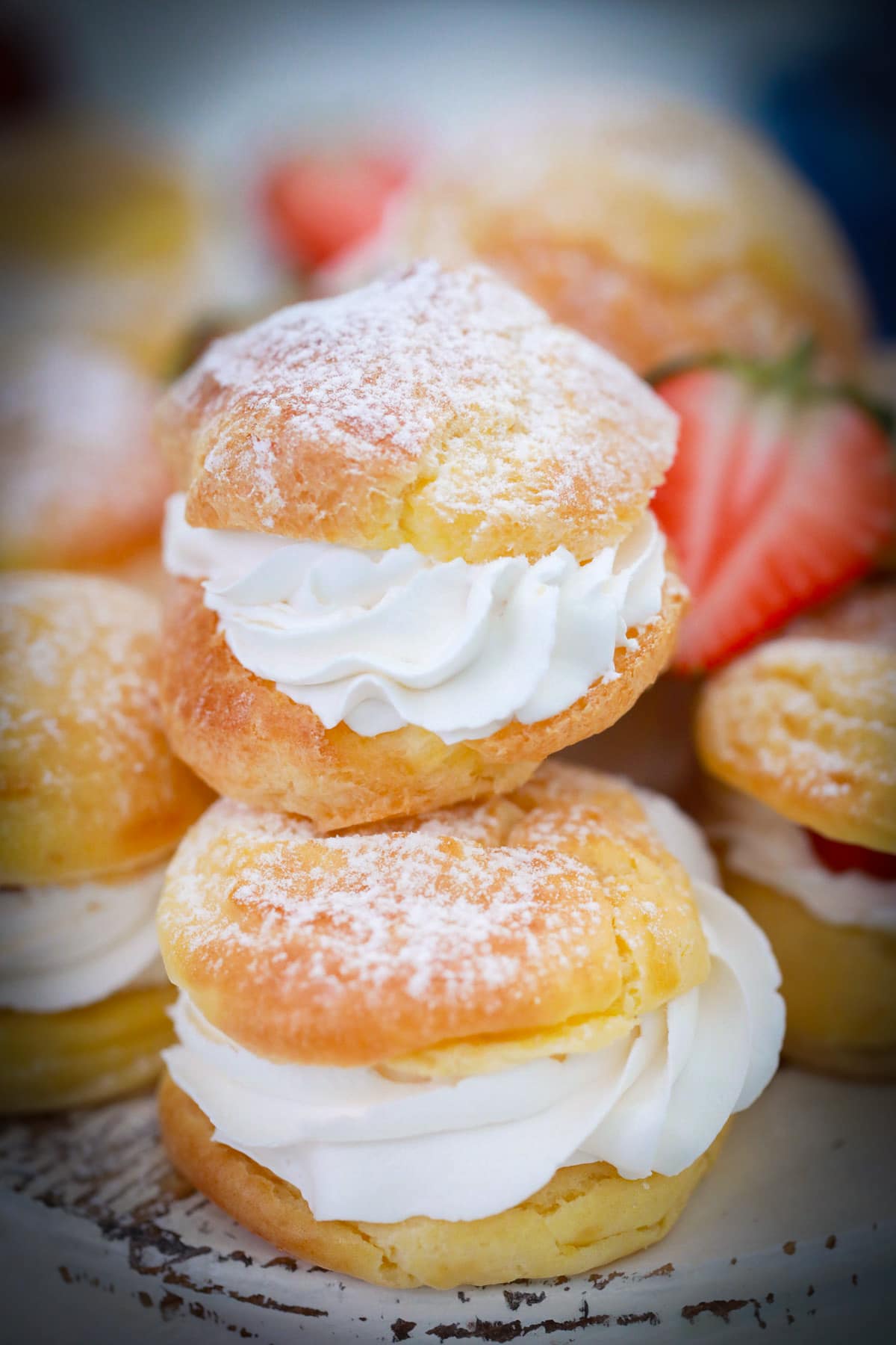 Two whipped cream filled cream puffs stacked on top fo each other.