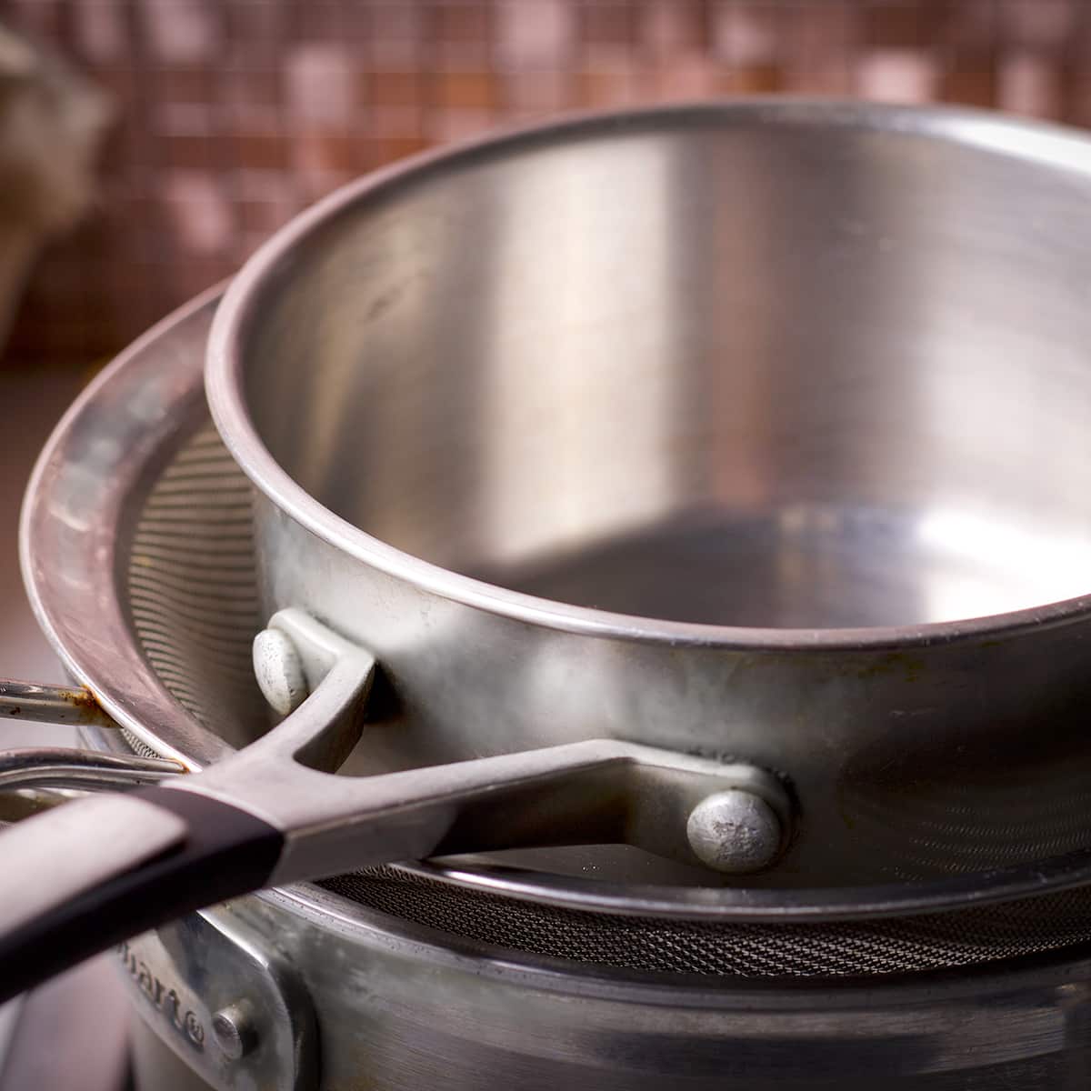 Two saucepans, one medium and one small, and a fine mesh strainer to create a double boiler.