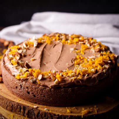 A one layer chocolate almond cake that's been frosted with chocolate orange buttercream and decorated with chopped almonds and orange zest.
