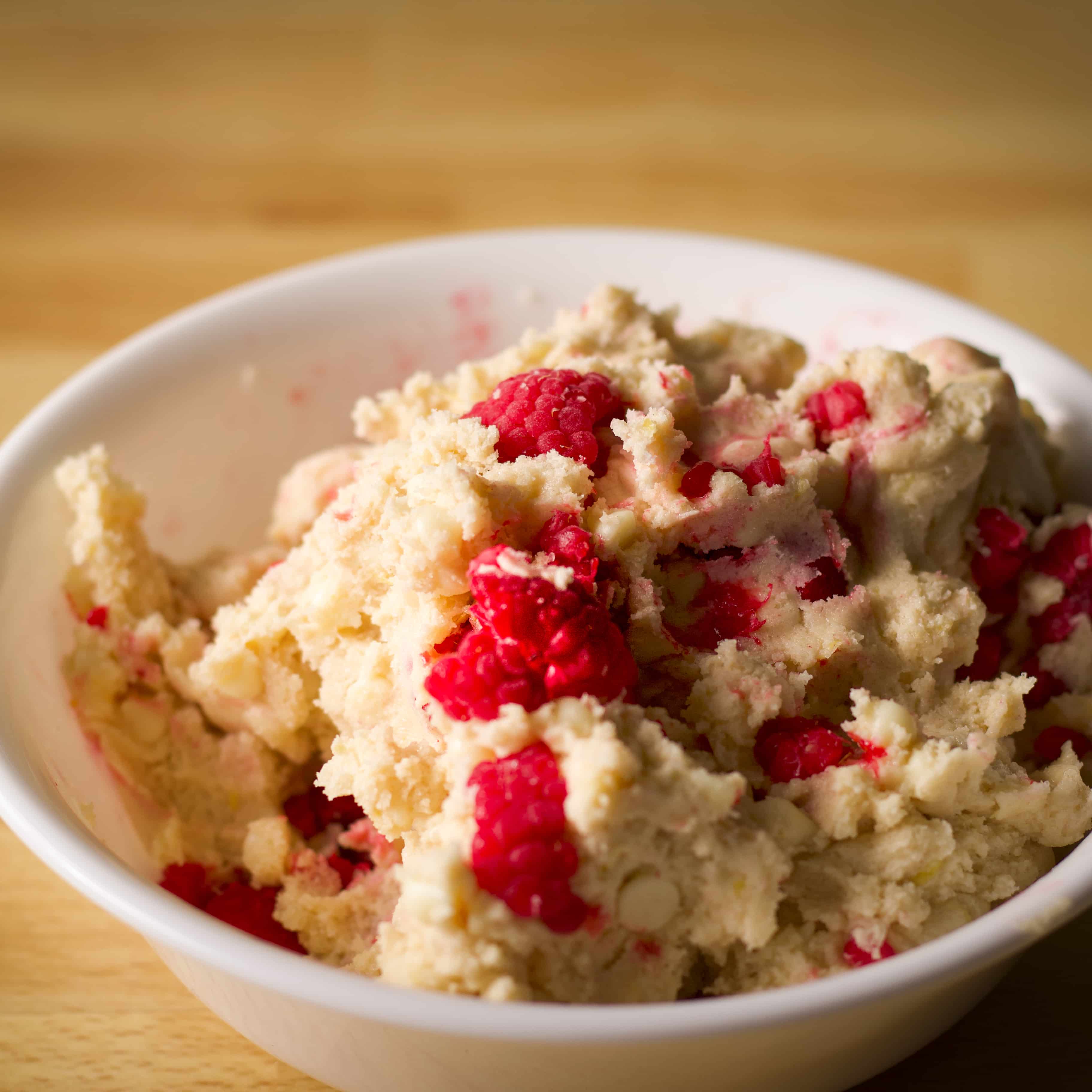 A white bowl filled with white chocolate raspberry cookie dough.