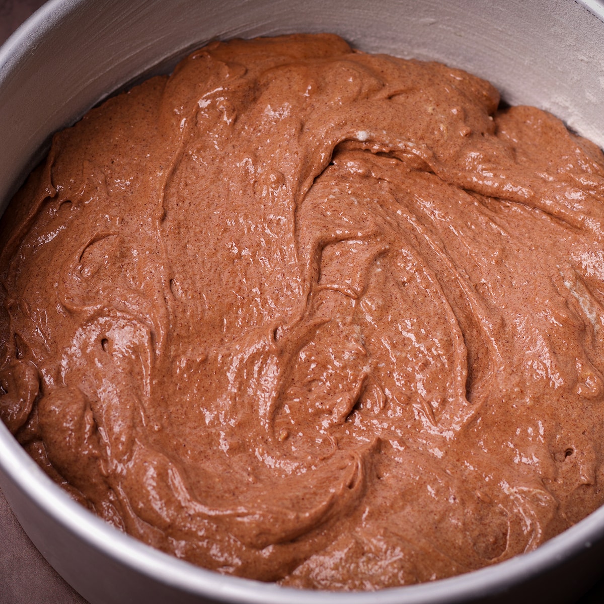 A cake pan that's been filled with chocolate almond cake batter.