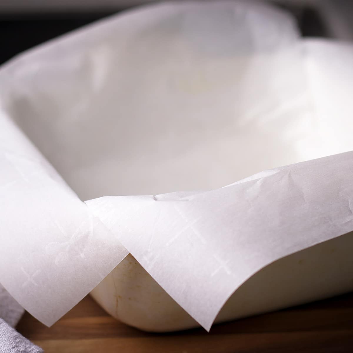 Two pieces of parchment paper set inside a baking dish to line the inside of the dish.