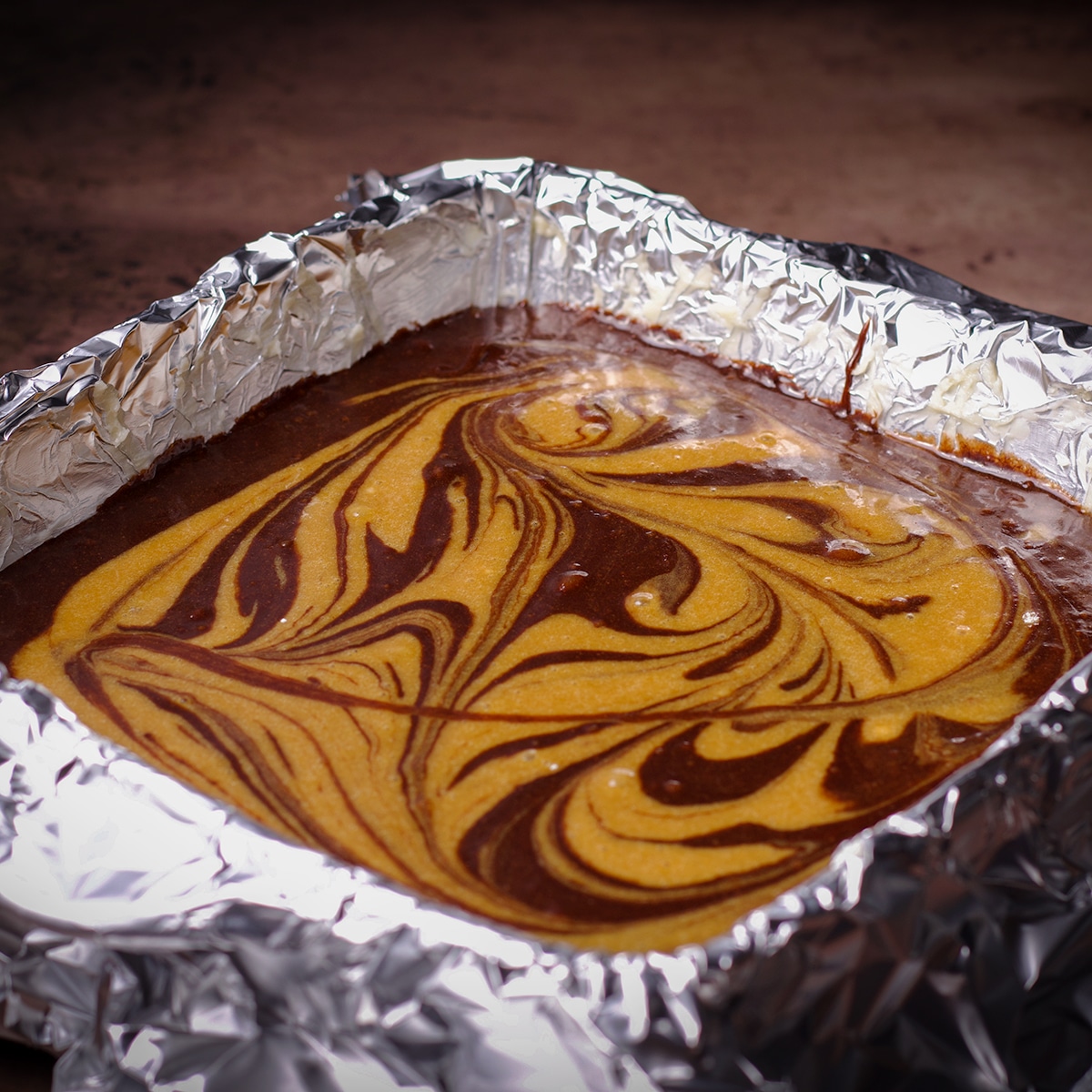 A pan filled with tahini brownie batter that's ready to be baked.