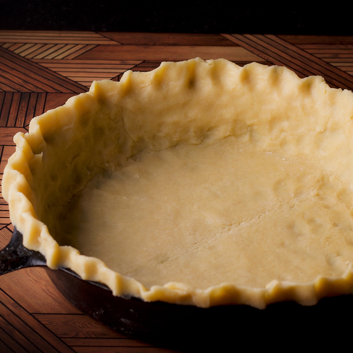 A cast iron skillet that's been lined with pie crust.
