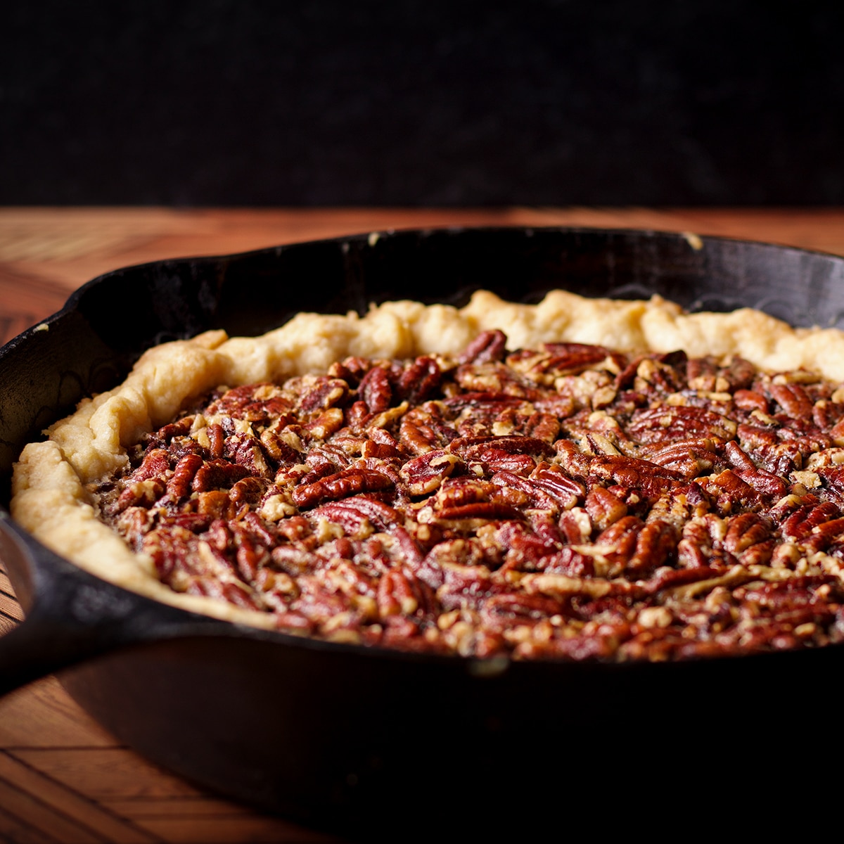 A freshly baked pecan pie in a cast iron skillet.