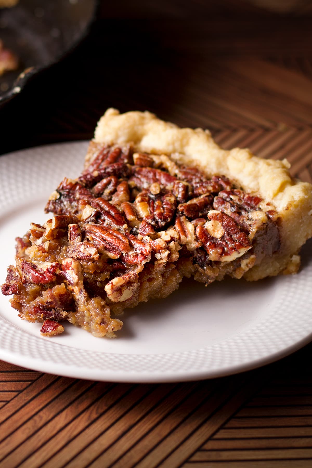 A slice of pecan pie on a white plate.