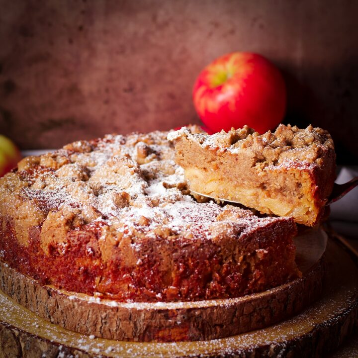 Using a cake server to serve a slice of French Apple Crumb Cake.