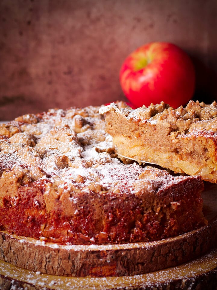 Using a cake server to serve a slice of French Apple Crumb Cake.