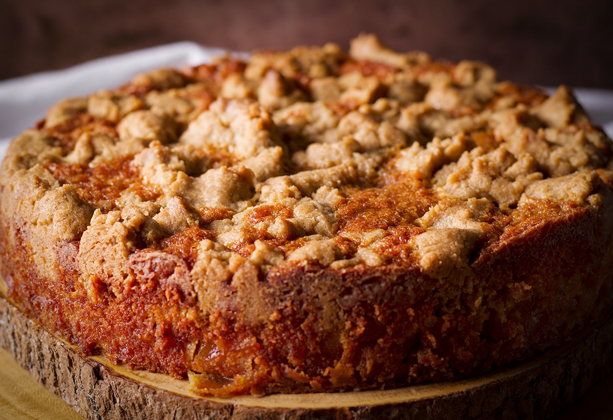 A French Apple Crumb Cake on a wood platter.