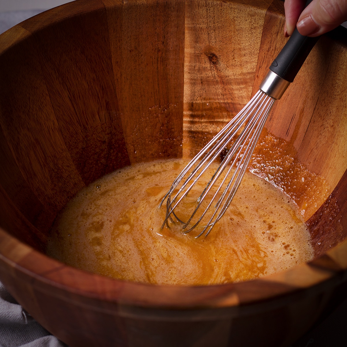 Using a wire whisk to blend eggs and brown sugar.
