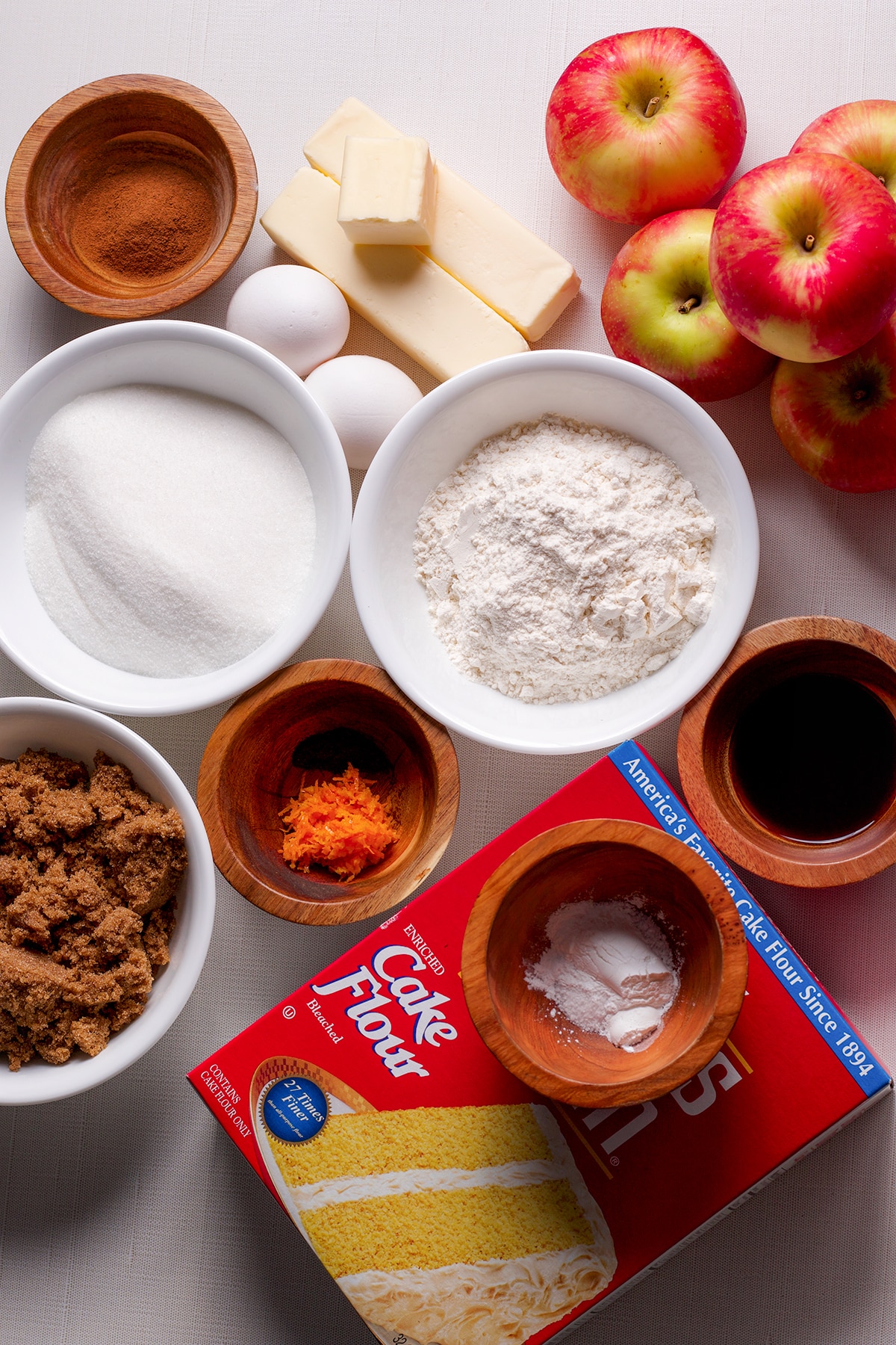 All of the ingredients needed to make French Apple Crumb Cake displayed on a white countertop.