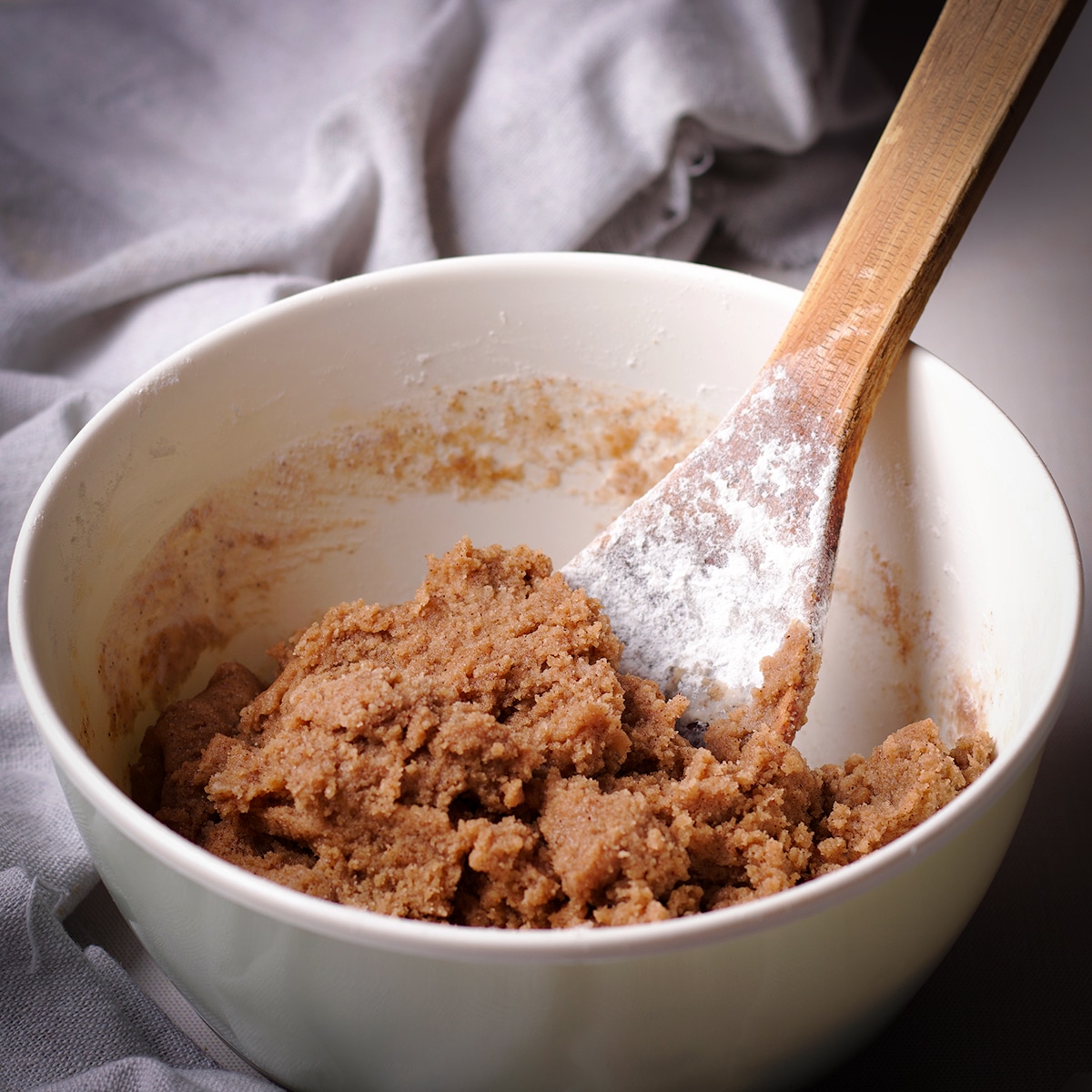 Using a wooden spoon to mix the ingredients for the crumb topping.