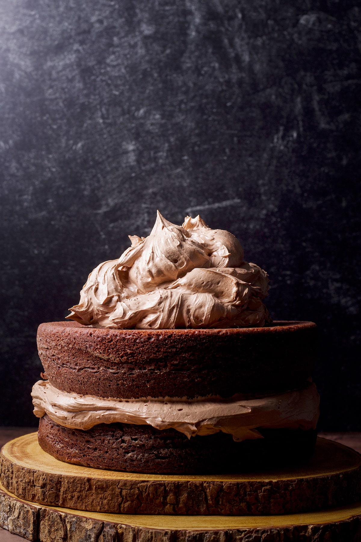 Two layers of chocolate cake that have been filled and topped with milk chocolate buttercream.