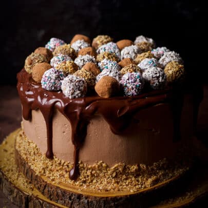 A chocolate truffle cake frosted with milk chocolate buttercream, covered in dark chocolate ganache and decorated with homemade chocolate truffles.