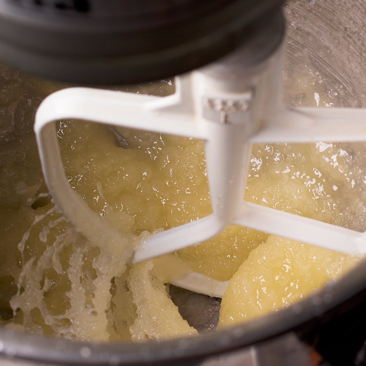 Using an electric mixer to beat butter and sugar.