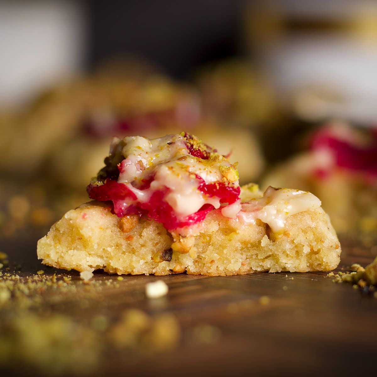 A cranberry pistachio cookie that's been broken in half to reveal the soft, buttery interior.