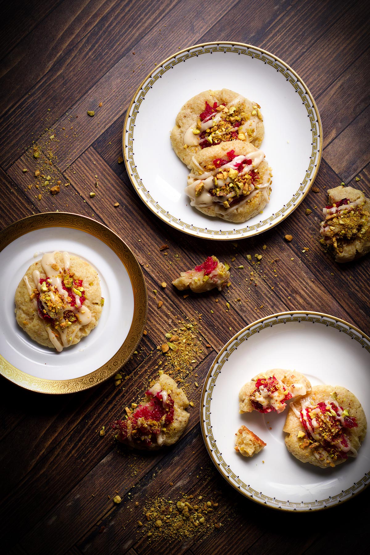 Three small plates containing cranberry pistachio cookies.