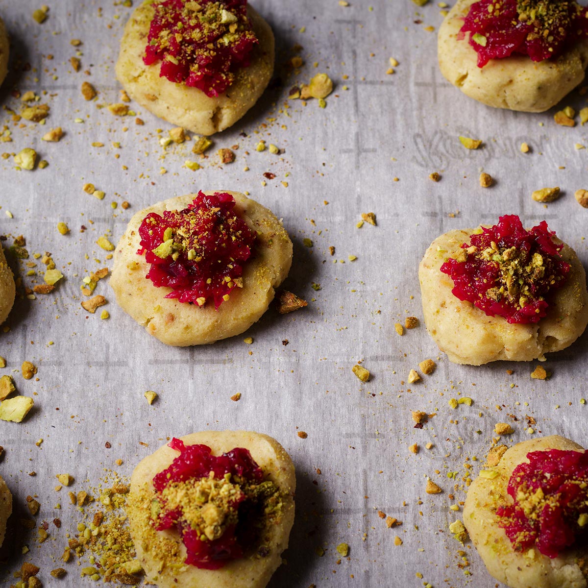 Pistachio cranberry cookies on a baking tray lined with parchment paper.