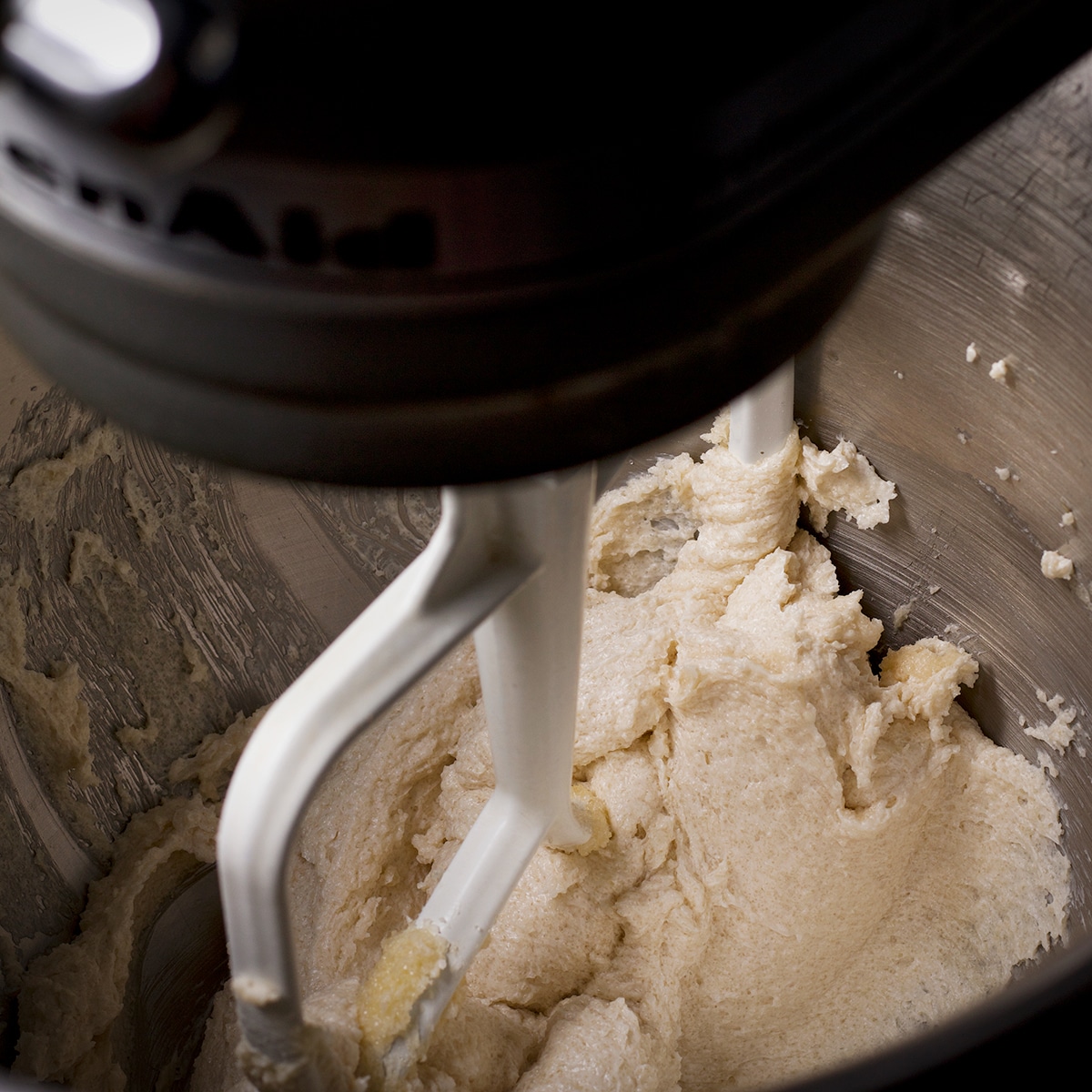 Using an electric mixer to beat butter and sugar until it's light in color and fluffy in consistancy.