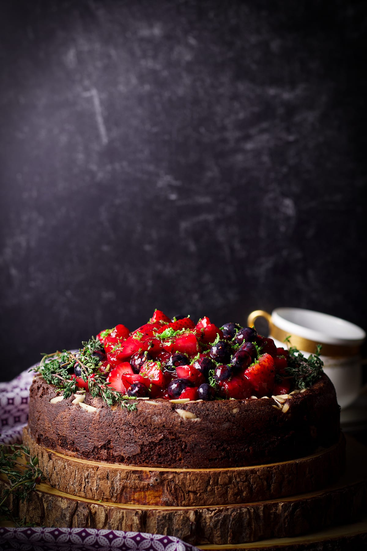 A chocolate ricotta cake made with almond flour covered in fresh berry sauce.